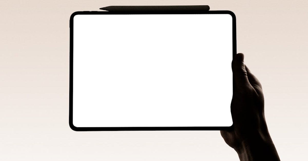 Mão de empresário a segurar um tablet a exibir um domínio web curto e impactante, simbolizando identidade digital exclusiva e valor de marca.